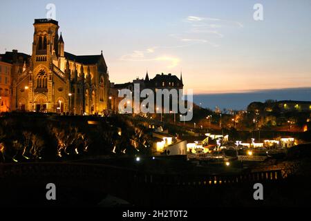 FRANKREICH, PYRENÄEN ATLANTIQUES (64) BASKENLAND, BIARRITZ, SONNENUNTERGANG AM MEER, DIE KIRCHE ST. EUGENIE UND CRAMPOTTES (ALTE FISCHERHÄUSER IN TH Stockfoto