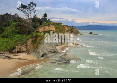 Die windgepeitschten Küstenklippen der Mahia-Halbinsel an der Ostküste der neuseeländischen Nordinsel Stockfoto