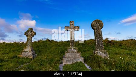 Grabsteine vor blauem Himmel auf dem Kirchhof der St. Matiana's Church, Tintagel Stockfoto