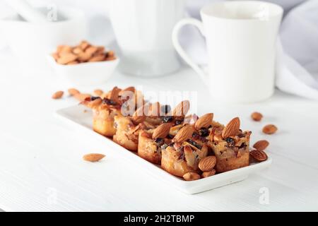 Kleine Kuchen mit Mandeln, Rosinen und Honig auf einem weißen Tisch. Stockfoto