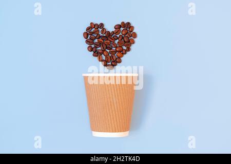 Kreative flache Lay mit Papier Einweg-Kaffeetasse und gerösteten Kaffeebohnen in Form eines Herzens auf pastellblauem Hintergrund. Umweltfreundliches und abfallfreundliches Konzept Stockfoto