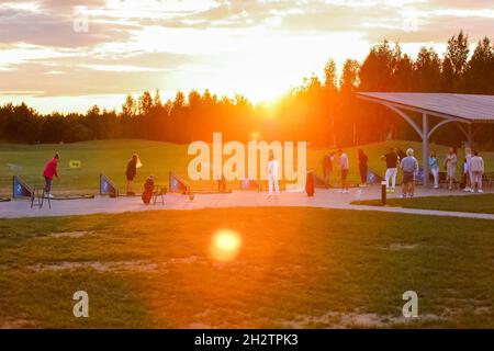 Golfplatz bei Sonnenuntergang, Sonnenstrahlen, Golfer am Abend in Sonnenstrahlen. Hochwertige Fotos Stockfoto