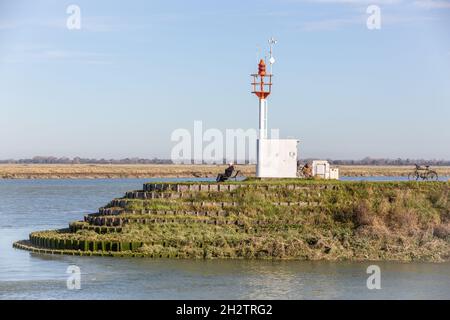 Leuchtfeuer, das den Zugang zum Hafen von Saint-Valery markiert, Mann, der auf einer Bank sitzt. Baie de Somme. Frankreich Stockfoto