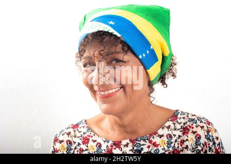 Porträt einer reifen, lächelnden brasilianischen Frau, die eine Bandana mit der Nationalflagge trägt Stockfoto