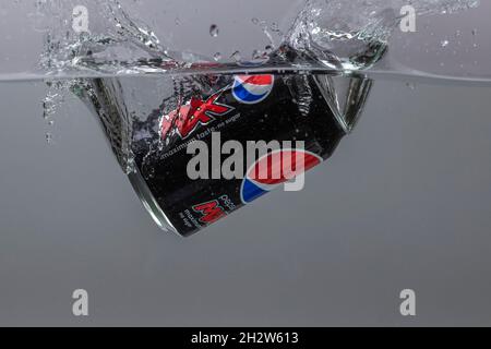 Nahaufnahme der Dose Pepsi Cola, die auf grauem Hintergrund in die Wasserisolation fällt. Schweden. Uppsals. Stockfoto