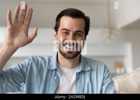 Glücklicher, tausendjähriger, gutaussehender Mann, der Videokonferenz hält. Stockfoto