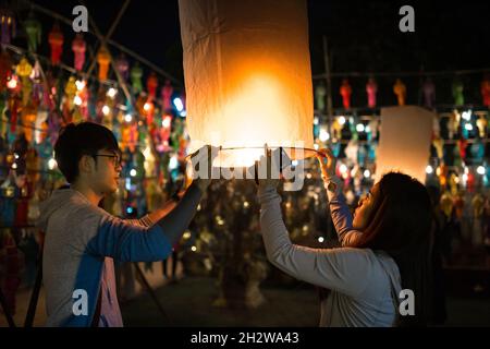 Chiang Mai, Thailand - 3. November 2017: Nicht identifizierte Menschen zünden die Laternen während des Loy Krathong Festivals an. Stockfoto