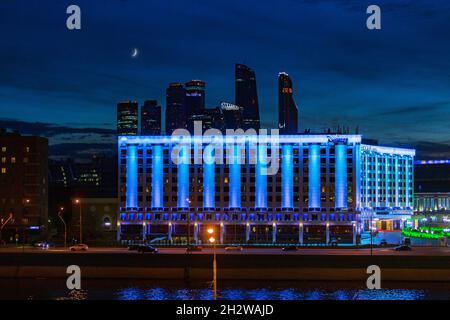 Moskau, Russland - 28. Mai 2017: Blick auf das farbenfrohe Radisson Slavyanskaya Hotel, das nachts im Moskova-Fluss beleuchtet ist. Stockfoto