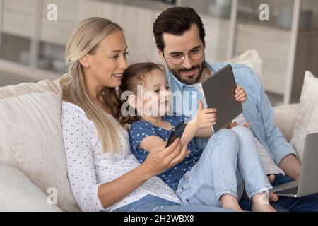 Süchtig nach moderner Technologie glückliche Familie mit verschiedenen Gadgets. Stockfoto