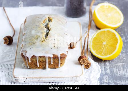 Zitronenkuchen mit Mohnsamen, bedeckt mit Glasur auf hellem Hintergrund. Stockfoto