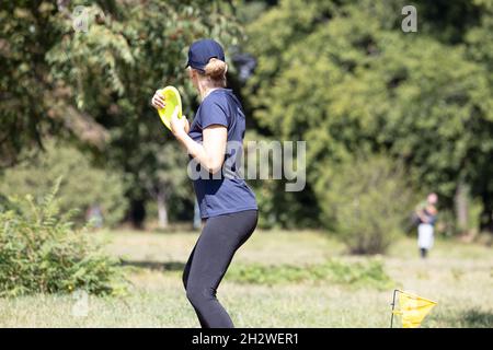 Junge Frau spielt fliegende Scheibe Sport-Spiel in der Natur Stockfoto