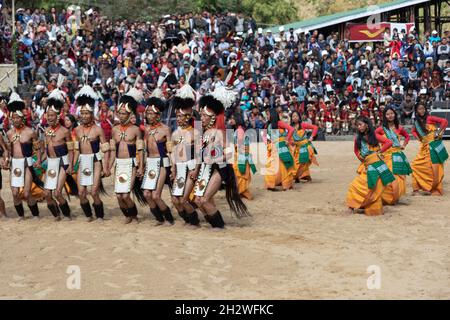 Eine Gruppe von Naga-Stammesmännern und -Frauen, die ihre traditionelle Kleidung trugen, tanzten während des Hornbill-Festivals in Nagaland, Indien, am 4. Dezember 2016 Stockfoto