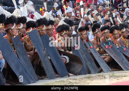 Naga-Stammesmänner, die am 3. Dezember 2016 in traditioneller Kriegerkleidung im Dorf Kisama in Nagaland Indien sitzen Stockfoto