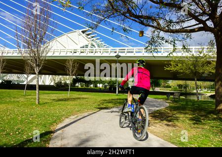 Radweg Spanien Valencia Stadt der Künste und Wissenschaften, ein Mann, der auf einem modernen europäischen Stadtradweg unter der Assut de l'Or Brücke Radfahren fährt Stockfoto