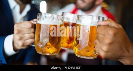 Eine Gruppe von Freunden toasten mit Gläsern leichten Bieres im Pub. Stockfoto