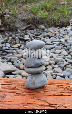 Ein Stapel von Kieselsteinen perfekt auf Holz ausbalanciert Stockfoto