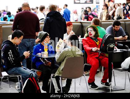 Am dritten Tag der MCM Comic Con im Excel London im Osten Londons sitzt ein Cosplayer, der als Joker aus der Batman-Serie mit Comic-Büchern und -Filmen gekleidet ist. Bilddatum: Sonntag, 24. Oktober 2021. Stockfoto