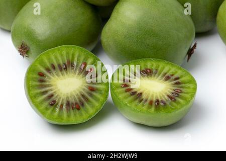 Frische ganze und halbierte Kiwi-Beeren aus der Nähe auf weißem Hintergrund Stockfoto