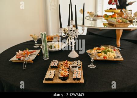 Sushi-Set mit Nigiri und Sushi-Rollen mit Kerzen auf dem Tisch im Restaurant Stockfoto