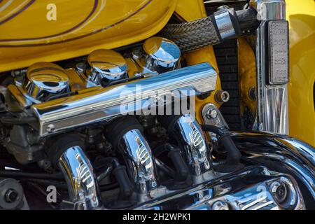 Detailaufnahme eines Motorrads, einer wiederaufgebauten Honda Valkyrie (Doc Willow Bike) in leuchtendem Gelb und vielen Chromteilen. Stockfoto