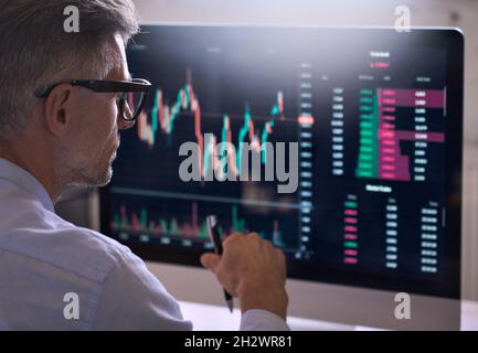 Krypto-Trader-Investor, der den Kryptowährungsmarkt mithilfe eines Computers analysiert. Stockfoto