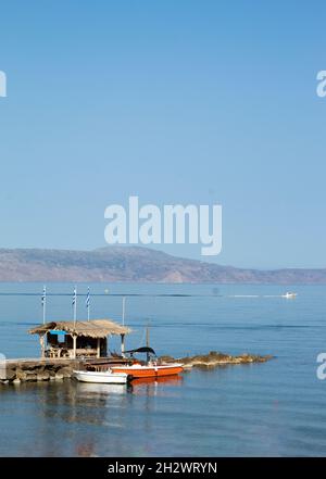 Agia Marina Resort, Chania, Kreta, Griechenland kleine Boote, die an einem hübschen Steg festgemacht sind, friedliche Landschaft mit Kopierplatz am blauen Himmel Vertikale Aufnahme Stockfoto