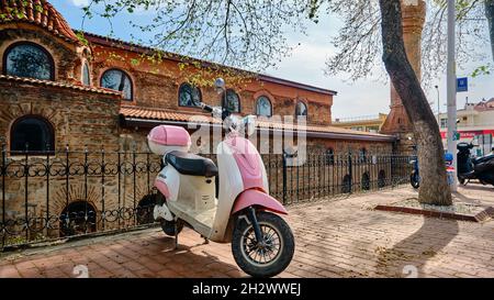 Rosafarbenes Mobilet und Roller (vespa) im Vintage- und Retro-Stil stehen auf dem Kopfsteinpflaster Stockfoto