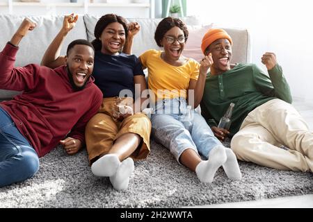 Glückliche schwarze Jugendliche genießen Fußballspiel zu Hause Stockfoto