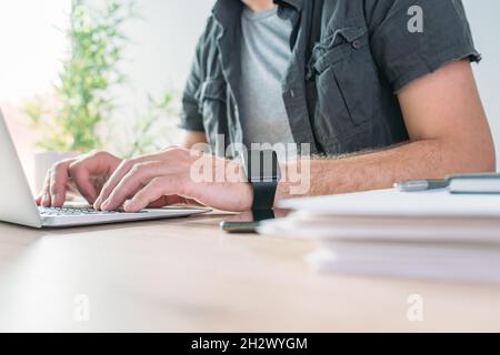 Freiberuflicher Mitarbeiter, der im Heimbüro die Tastatur eines Laptops eingibt, selektiver Fokus Stockfoto