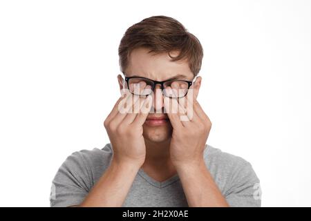 Millennial kaukasischen Kerl in Brille reibt Augen, leidet an Trockenheit, isoliert auf weißem Hintergrund. Augen sind aufgerissenen Stockfoto