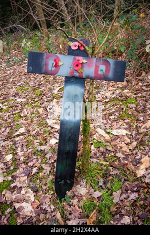 Hölzernes Kreuz mit Papa und roten Mohnblumen Stockfoto