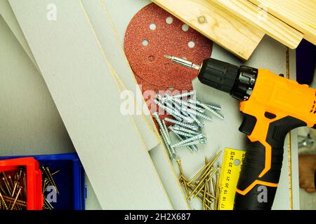 Werkzeuge für Reparatur und Bau. Schraubendreher, Möbelschrauben, Maßband, selbstschneidende Schrauben, mit Platz für Text. Draufsicht. Stockfoto