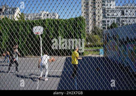 Kinder spielen Basketball auf einem geschlossenen Platz, Sport im Jardins d’Éole, 20 Rue du Département, 75018 Paris, Frankreich Stockfoto