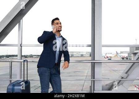 Schöner Junger Mann Aus Dem Nahen Osten, Der Am Flughafen Auf Dem Mobiltelefon Spricht Stockfoto