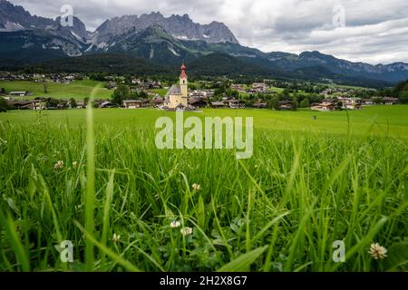 Gelbe Ortskirche in Ellmau. Das Dorf Going. Wilden Kaiser Berge im Hintergrund. Tirol, Alpen, Österreich Stockfoto