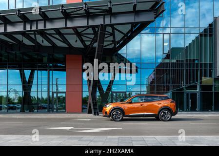 Kiew, Ukraine - 12. Juni 2021: Frau fährt den neuen Peugeot 2008 entlang der Glaswand eines modernen Einkaufszentrums Stockfoto