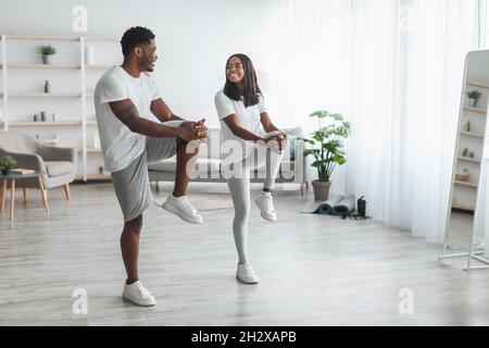 Junge schwarze Paar tun hohe Knie-Übung Stockfoto