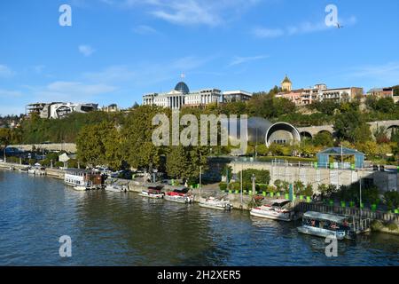 Tiflis, Georgien - 24. Oktober 2021: Das Panorama der georgischen Hauptstadt mit dem Fluss Kura, dem Präsidentenpalast, Tbilisi Music Theatre und Konzert Stockfoto