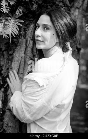 Frau an einem Baum gelehnt Stockfoto