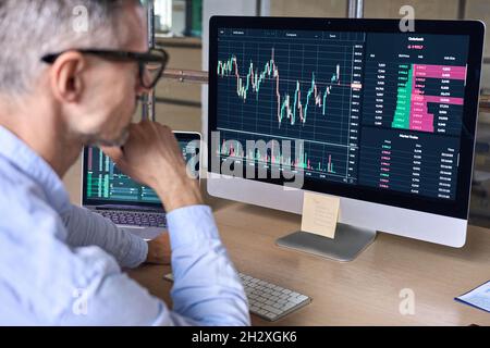 Krypto-Trader-Investor-Analyst, der sich mit der Analyse von Daten auf einem pc-Monitor am Computer ansieht. Stockfoto