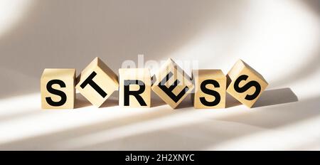 Stress - Wort aus Holzblöcken mit Buchstaben, große Sorge durch eine schwierige Situation Stress-Konzept verursacht, zufällige Buchstaben um weißen Hintergrund Stockfoto