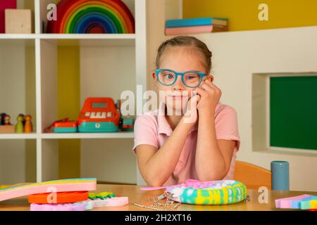 Ein Mädchen mit Down-Syndrom hat Spaß popit Stockfoto