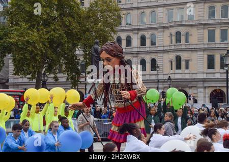 London, Großbritannien. Okt. 2021. Little Amal tritt im Rahmen der Feierlichkeiten zu ihrem 10. Geburtstag auf dem Trafalgar Square mit Tänzern auf.Little Amal ist eine 3.5 Meter hohe Marionette, die ein syrisches Flüchtlingskind darstellt, dessen Reise nahe der türkisch-syrischen Grenze begann und 8,000 km quer durch Europa nach Großbritannien zur Unterstützung von Flüchtlingen reiste. (Foto: Vuk Valcic/SOPA Images/Sipa USA) Quelle: SIPA USA/Alamy Live News Stockfoto