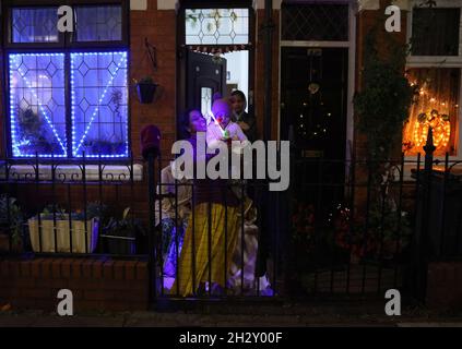 Leicester, Leicestershire, Großbritannien. Oktober 2021. Eine Familie stand in ihrem Garten, nachdem die Diwali-Lichter eingeschaltet wurden, was sich von der normalen Veranstaltung Unterschied, ohne dass es wegen der Sorgen um Covid-19 eine Hauptbühne oder ein Feuerwerk gab. Credit Darren Staples/Alamy Live News. Stockfoto