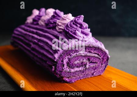 Ube Cake Roll mit Schlagsahne Frosting: Roulade mit violetten Süßkartoffeln und Schlagsahne aus der Sahneeibe Stockfoto