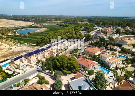 Luftaufnahme Pinar de Campoverde Stadtbild mit künstlichen See, moderne Luxus vorstädtischen Wohnhäuser Mittelmeer während sonnigen Tages. Costa Bl Stockfoto
