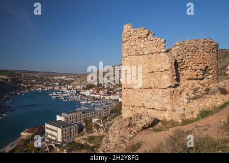 Foto der Küstenlandschaft mit der ruinierten alten Festung Balaklava, die an einem sonnigen Tag aufgenommen wurde, ist es eine Siedlung auf der Halbinsel Krim und ein Teil der CI Stockfoto