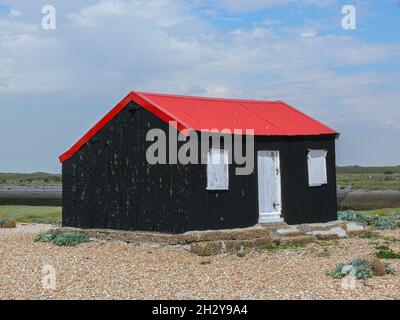 Isolierte schwarze Hütte am Strand im Rye Nature Reserve, Sussex Stockfoto