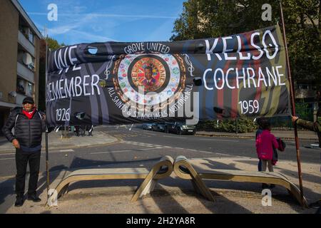 London, England, Großbritannien 24. Oktober 2021 die Gemeinschaftsgruppe Grove United erinnert sich an das Leben von Kelso Cochrane, der 1959 im Rahmen des Black History Month den ersten registrierten rassistischen Mord in Großbritannien erlitt. Marcia Haynes von Grove United und Felicity Buchan, Abgeordnete für Kensington und Chelsea, schlossen sich der Gruppe an. An der Ecke der Golborne Road oberhalb des Cha Cha & Sister Jane Restaurants ist eine Gedenktafel für Kelso Cochrane angebracht. Es fand eine Prozession von der Stelle, an der er starb, zur St. Michaels Kirche in Ladbroke Grove statt. Stockfoto