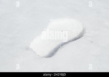Ein menschlicher Schritt im frischen weißen Schnee. Konzept Stockfoto